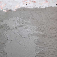 Warstwa podkładu Ceresit CR 61 na ścianie podczas aplikacji na wilgotne podłoże mineralne