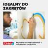 Mężczyzna precyzyjnie przykleja taśmę malarską Tesa na ścianie z zaokrąglonym wzorem