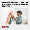 Kobieta nakleja elastyczną taśmę malarską Tesa na ścianie z kolorowym motywem łuku
