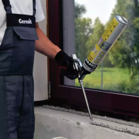 Pracownik aplikuje poliuretanowy Ceresit CX10 na powierzchnię przy oknie podczas montażu
