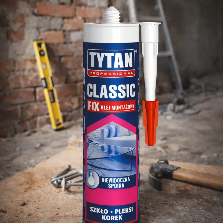 Zbliżenie na tubę bezbarwnego kleju Tytan Classic Fix stojącą na tle remontowanego pomieszczenia