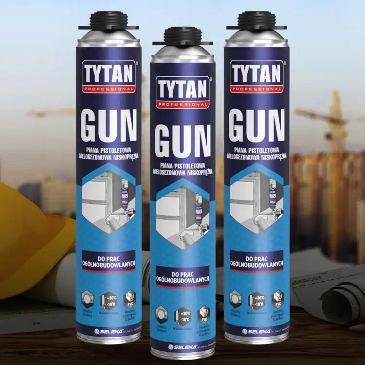 Trzy puszki Tytan GUN ustawione obok siebie na tle budowy z widocznymi żurawiami