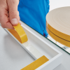 Zwoje taśmy piankowej Tesa 4957 widoczne podczas precyzyjnego przygotowania do montażu na białej ramie
