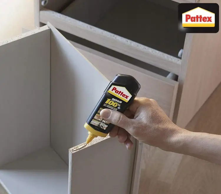 Aplikacja kleju Pattex Repair Total na krawędź półki podczas montażu mebli drewnianych