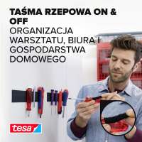 Mężczyzna mocuje narzędzia na ścianie za pomocą czarnej taśmy rzepowej Tesa