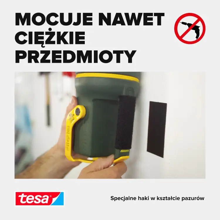 Czarny rzep Tesa przytrzymuje ciężką latarkę na białej ścianie bez użycia gwoździ