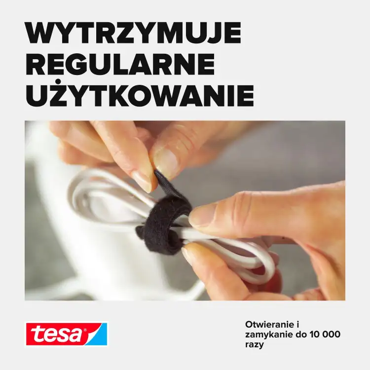 Palce zapinają czarną taśmę Tesa na białych kablach, podkreślając trwałość zapięcia organizera