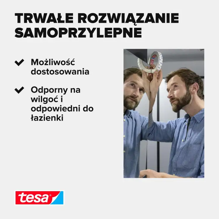 Mężczyzna odkleja fragment dwustronnej taśmy montażowej Tesa przy lustrze w nowoczesnej łazience
