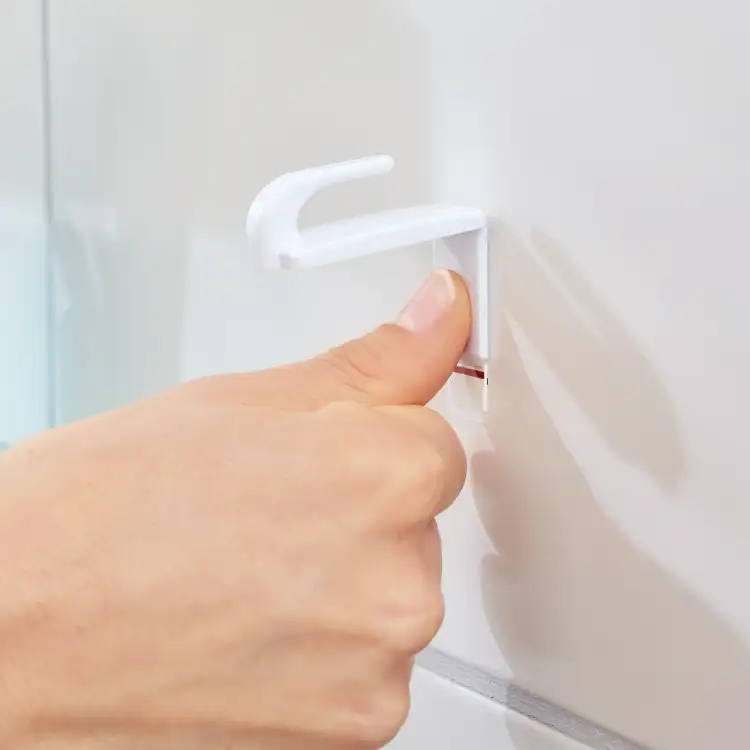 Kciuk dociska biały haczyk Tesa Powerstrips do gładkiej łazienkowej płytki ściennej