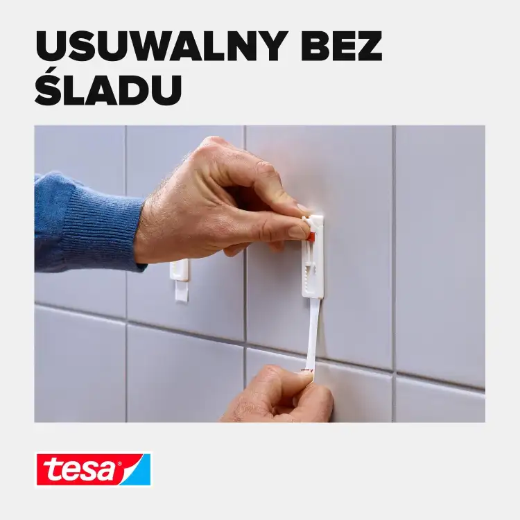 Ręka z łatwością usuwa pasek montażowy Tesa z płytki bez pozostawiania śladów