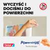 Ręka mocuje plakat do ściany za pomocą samoprzylepnego paska montażowego Tesa Powerstrips