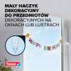 Transparentny haczyk Tesa zamocowany na szybie okna utrzymuje kolorowy napis Happy Birthday