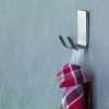 Na srebrnym metalowym haczyku łazienkowym Tesa Powerstrips wisi czerwona kraciasta ściereczka