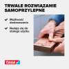 Mężczyzna przykleja dwustronną taśmę klejącą Tesa do drewnianej listwy podczas montażu na płytkach