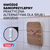 Na zdjęciu samoprzylepny gwóźdź Tesa utrzymuje zegar ścienny na płytkach ceramicznych w łazience