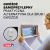 Kobieta zawiesza ramkę na ścianie przy pomocy samoprzylepnego gwoździa Tesa do tapet