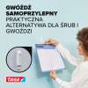 Kobieta zawiesza planner na ścianie przy użyciu samoprzylepnego gwoździa Tesa do tapet
