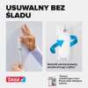 Dłoń zdejmuje haczyk samoprzylepny Tesa do tynku, prezentując łatwość usuwania bez śladów