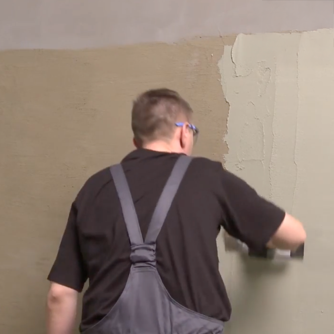 Aplikacja mineralnej zaprawy uszczelniającej Ceresit CR 65 na ścianę przy użyciu pacy budowlanej