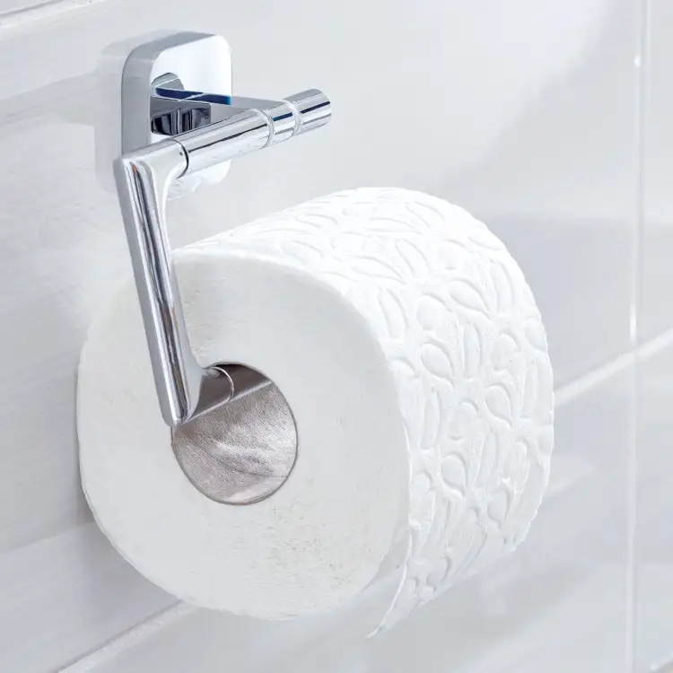Chromowany uchwyt Tesa ELEGAANT prezentuje eleganckie zawieszenie rolki papieru na białych płytkach
