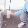 Osoba czyści toaletę przy użyciu metalowej szczotki WC Tesa ELEGAANT w nowoczesnej łazience